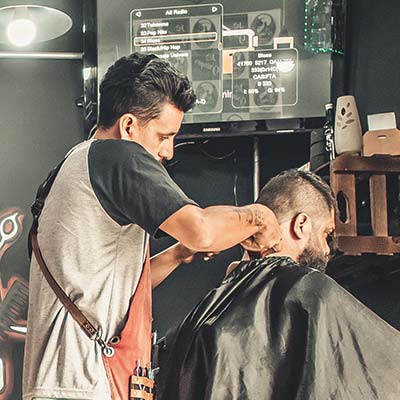 Фотографія перукаря під час обслуговування клієнта